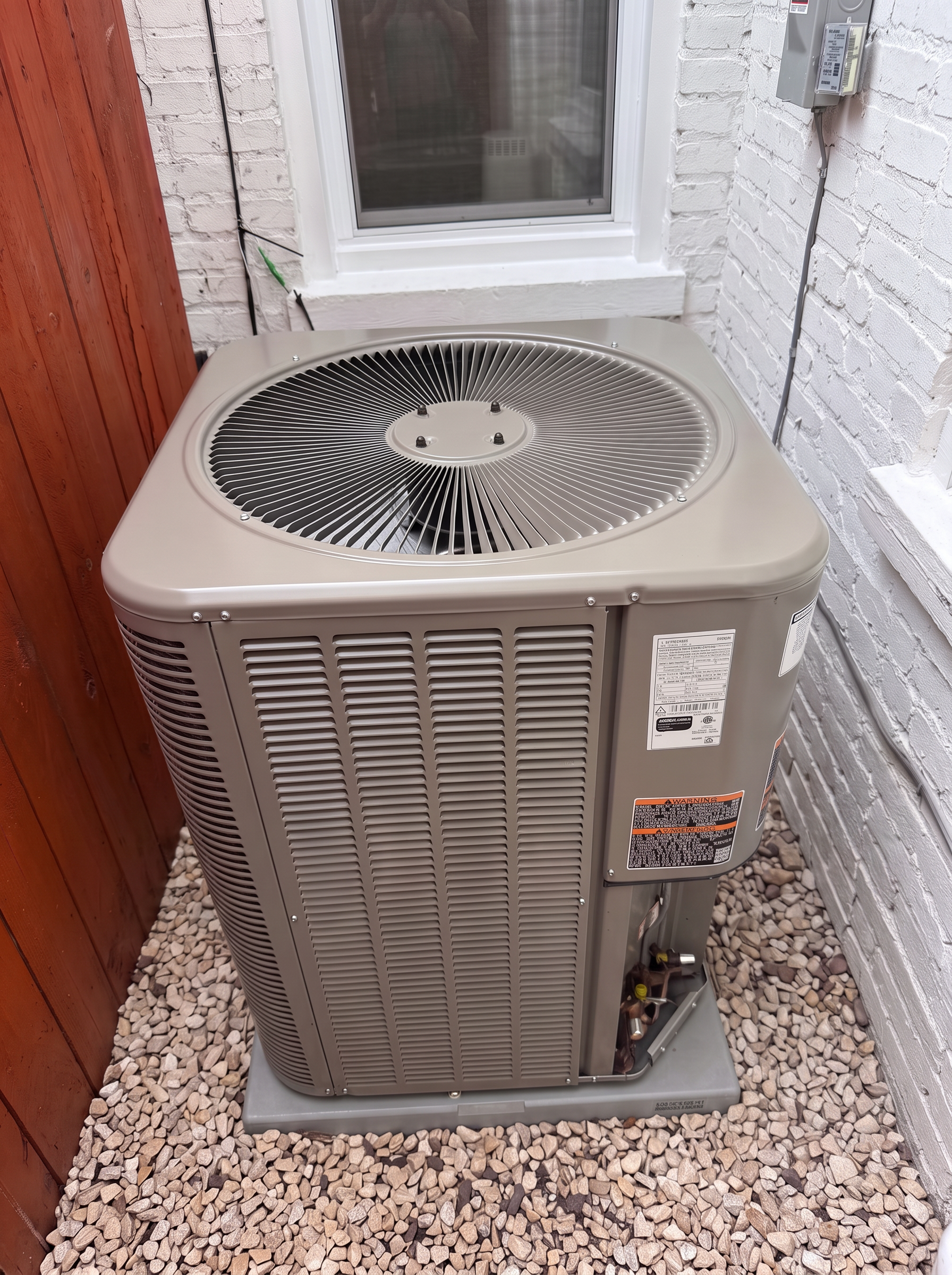 New Lennox outdoor air-conditioning condenser beside the white brick wall at 749 Kenyon Street NW