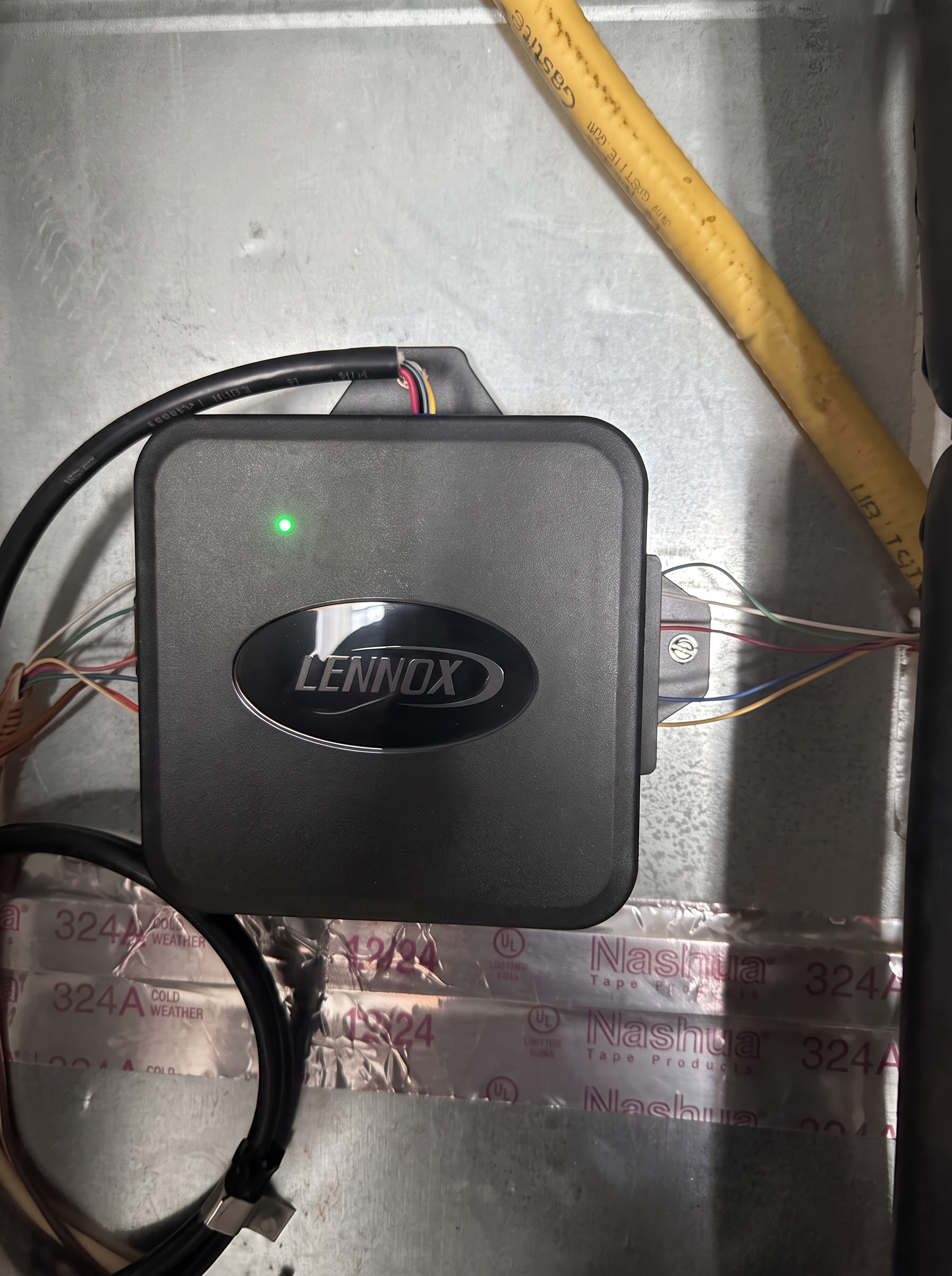 Lennox control module inside the furnace cabinet with its green status light lit